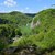 Dolina Prądnika widziana z punktu widokowego na zielonym szlaku pomiędzy jaskinią Ciemną a Prądnikiem Czajowskim. Widok w kierunku Bramy Krakowskiej z widoczną górą Chełmową